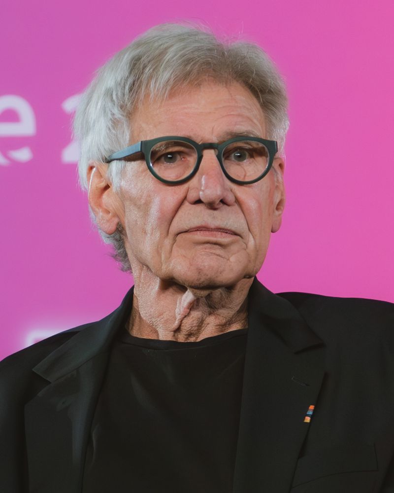 Harrison Ford in round dark-framed glasses at a 2025 event.