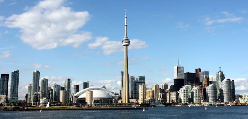 The Toronto skyline across the water on a sunny day, with the CN Tower at the centre.