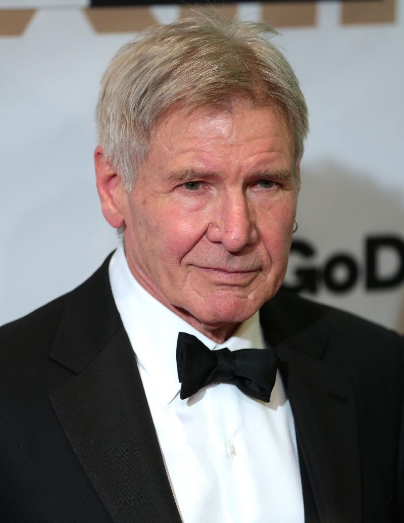 Harrison Ford in a black tuxedo and bow tie at an awards event.
